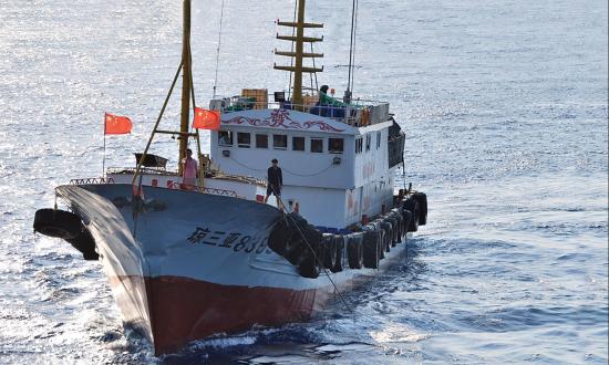 A crewmember on a Chinese trawler uses a grapple hook in an apparent attempt to snag the towed acoustic array of the military Sealift Command ocean surveillance ship USNS Impeccable (T-AGOS-23)